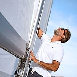 Ein Skipper kontrolliert ein Segel einer Yacht