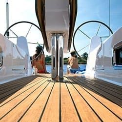 Zwei Kinder entspannen am Heck einer Yacht